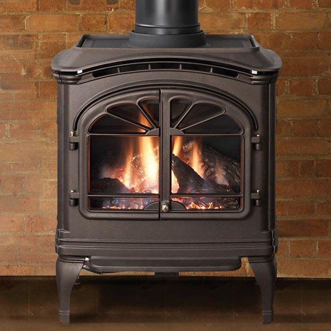 A cast iron wood stove with double doors, burning