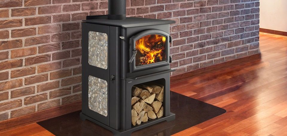 A freestanding wood stove burning on a hearth pad